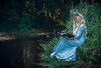 Low angle view of woman standing by lake