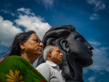 Low angle view of man and woman against sky