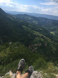 Low section of woman wearing shoes on mountain