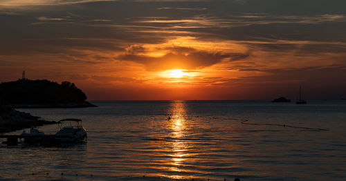 Sunset over horizon at sea, summer, orange, sky, clouds, sun.