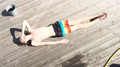 High angle view of woman lying on wooden floor