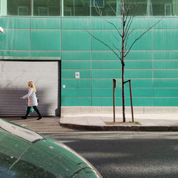 Woman standing by road in city