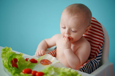 Child eats salad, tomatoes with sausage