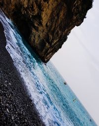 Rock formations by sea against sky