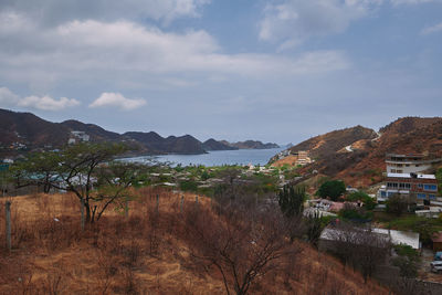 Scenic view of town by mountains against sky