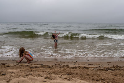 Girls playing on beach on a cloudy summer day