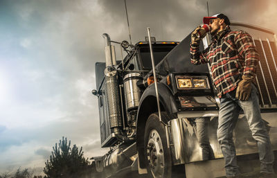 Rear view of man standing on car