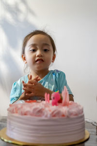 Portrait of girl by cake