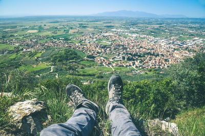 Trekking shoes and mountain panorama. male legs, feet with technical hiking boots. relax on the top