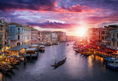 Boats in canal amidst buildings in city