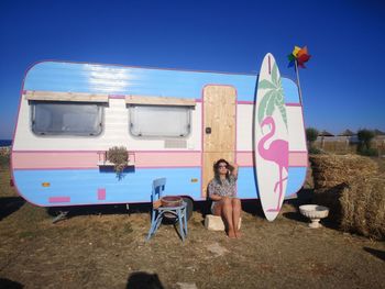 Full length portrait of friends against blue sky