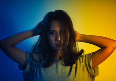 Portrait of woman standing against wall