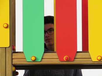 Portrait of boy seen through colorful play equipment