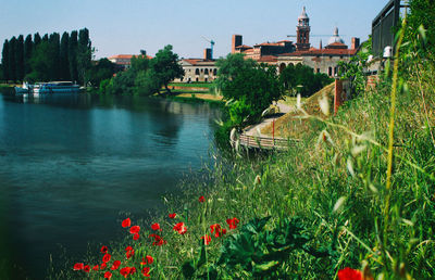 Scenic view of lake against sky in city