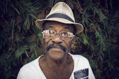 Portrait of man wearing hat against stone wall