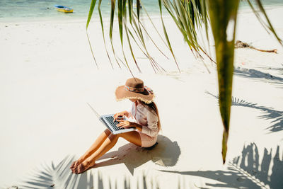 High angle view of woman sitting on beach