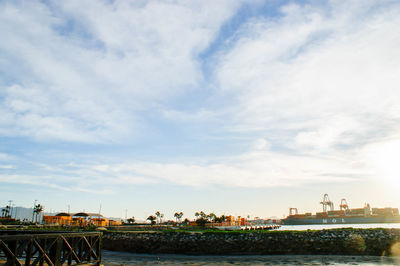 River by buildings in city against sky