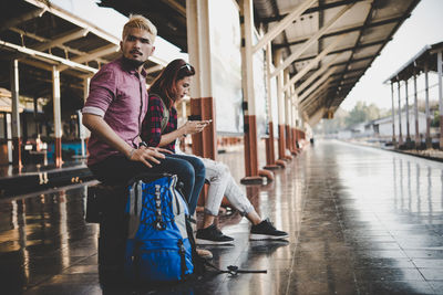 Friends on seat at railroad station platform