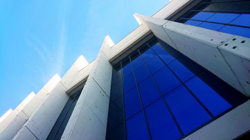 Low angle view of modern building against blue sky