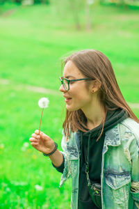 Young woman with arms outstretched standing on field