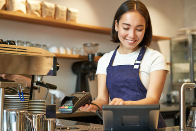 Portrait of young woman standing in cafe