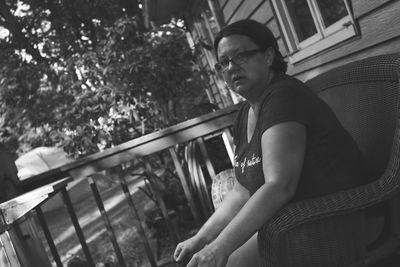 Tilt portrait of woman sitting in chair at back yard