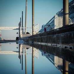 Reflection of building in water against clear sky