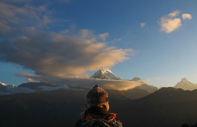 Rear view of woman standing against mountains during winter