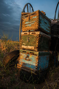 Abandoned boat on field against sky