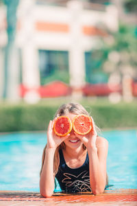 Portrait of young woman with ice cream in swimming pool