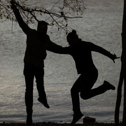 Silhouette men standing on beach against sky