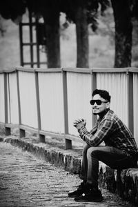 Side view of young man sitting outdoors