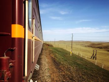 Road amidst field against sky