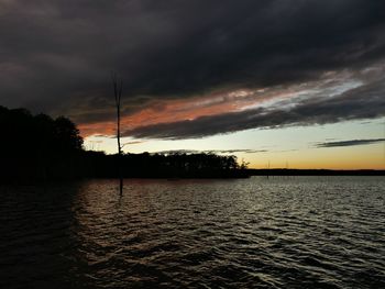 Scenic view of dramatic sky over lake during sunset