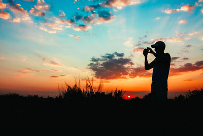 Silhouette man standing against sky during sunset