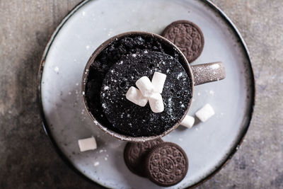 Close up of chocolate cake with marshmallows and powdered sugar for homemade dessert top view