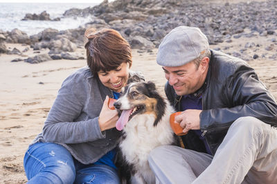 Couple sitting with dog at beach
