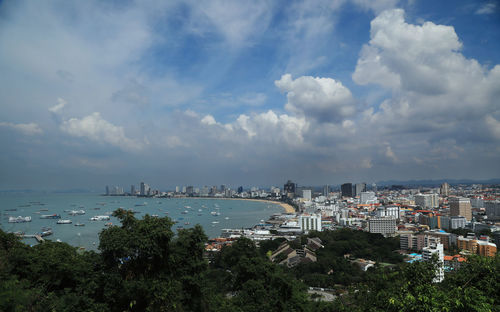 High angle view of city by sea against sky