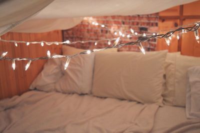 Illuminated string lights over bed at home