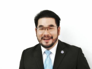 Portrait of smiling businessman against white background