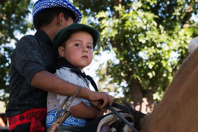 South american brothers riding horse