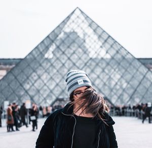 Woman with umbrella against sky in winter