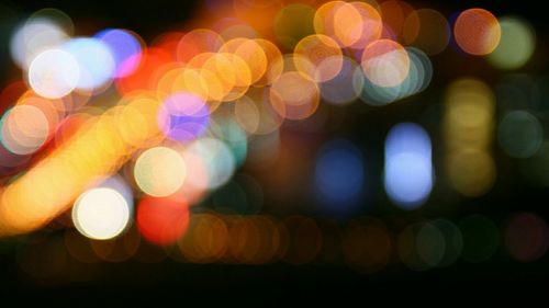 Defocused image of illuminated colorful lights at night