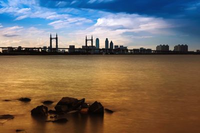 View of city at waterfront during sunset