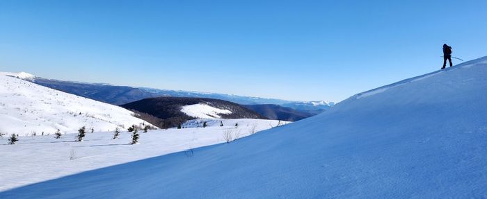 Scenic view of snowcapped mountains against clear blue sky