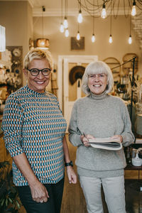 Happy senior female owners standing together at home decor shop