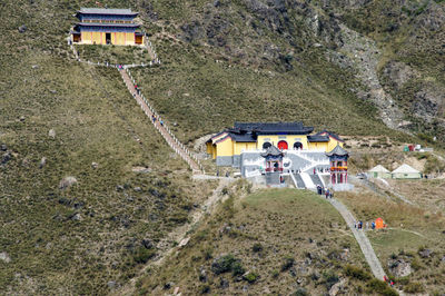 Buddhist temples and high angle view of visitors on stairs.