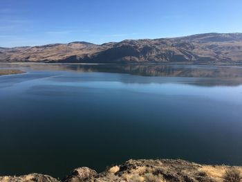 Scenic view of lake and mountains against clear sky