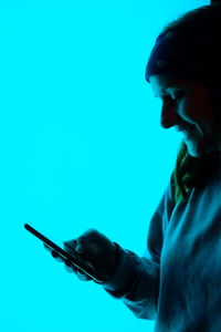 Portrait of boy looking away against blue background