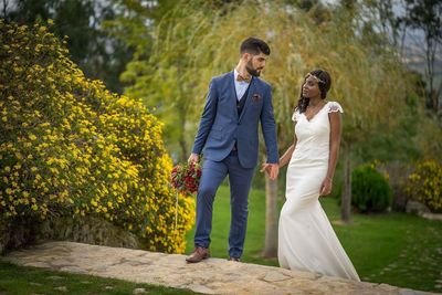 Bride and groom walking on steps by plants at park